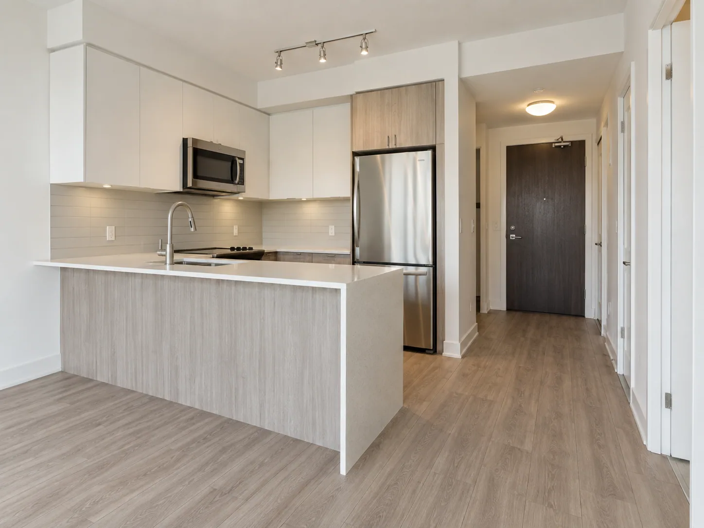 A bright empty condo kitchen and entry prepared for a real-estate milestone